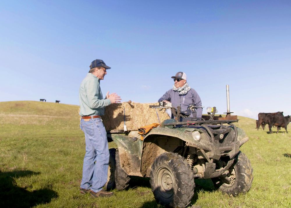 Andrew Zimmern listens to Stan Van Vleck discuss his family's history at Van Vleck Ranch in northern California.