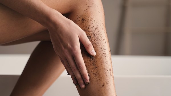 Woman using body scrub on legs