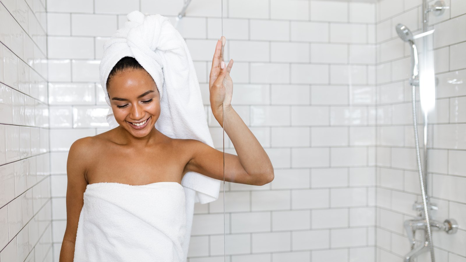 Young woman in white towels wrapped around head and body after shower