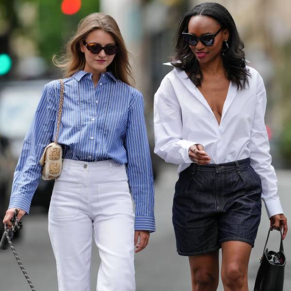 PARIS, FRANCE - MAY 20: Segolene Hyppolite (L) wears sunglasses, a blue and white oversized shirt from Tommy Hilfiger, a raffia beige bag from Vanessa Bruno, high waist white denim pants from Vanessa Bruno ; Emilie Joseph (R) wears a summer wardrobe capsule: an oversized white poplin button-down shirt from Figaret Paris , tucked into high-waisted denim bermuda/ jorts / denim shorts, classic / basic / timeless accessories such as black sunglasses from the Korean fashion brand Gentle Monster, a small black top handle leather handbag, during a street style fashion photo session, on May 20, 2024 in Paris, France. (Photo by Edward Berthelot/Getty Images)