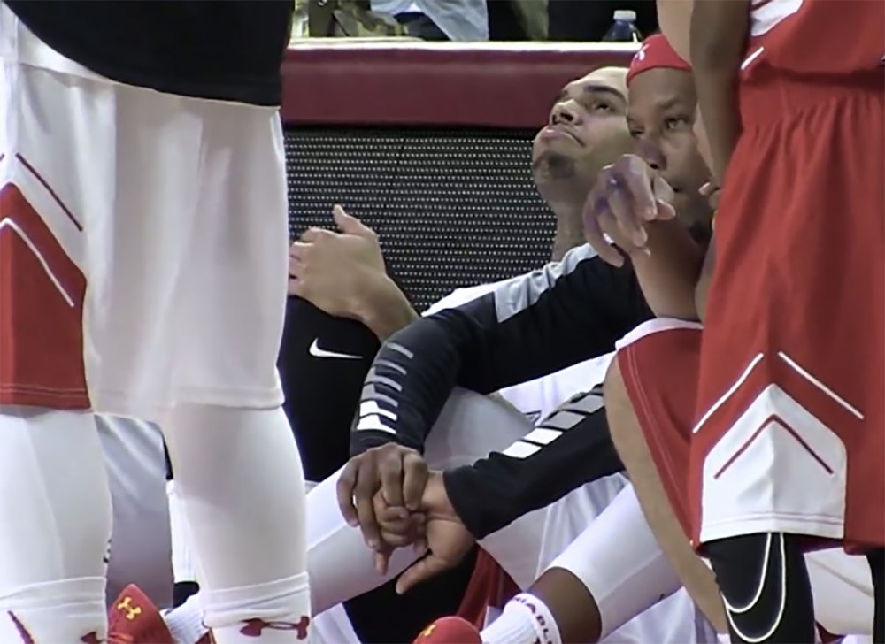 Chris Brown smiles as he sits during the national anthem on the 15th anniversary of 9/11.