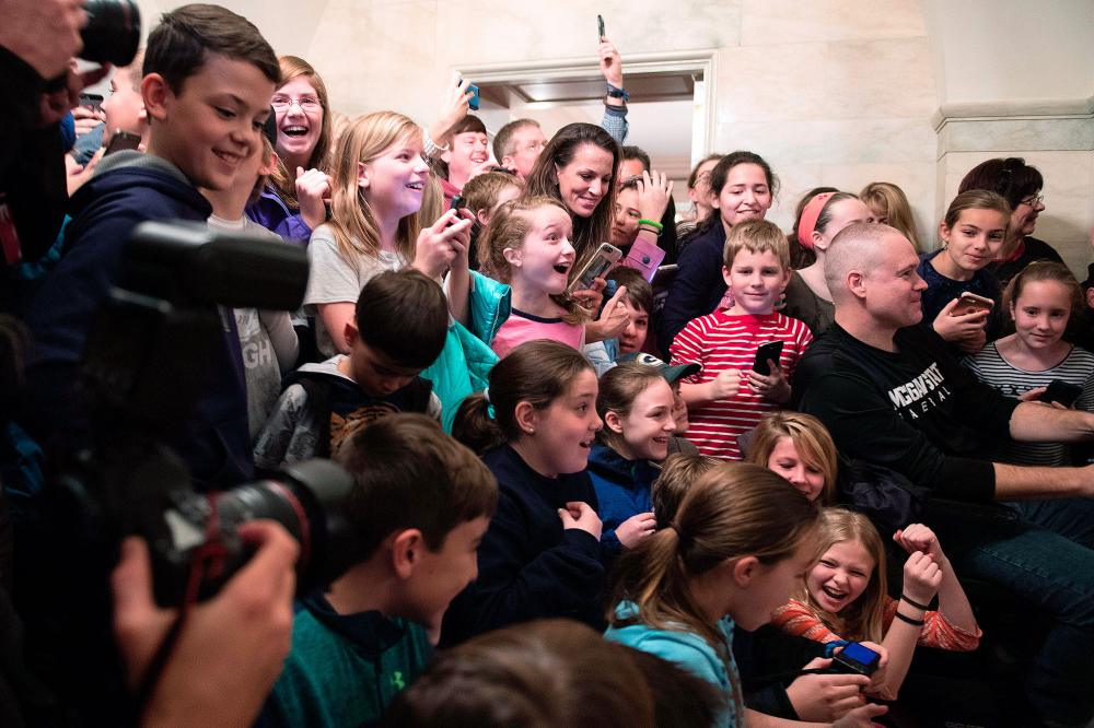 The crowd reacts as US President Donald Trump surprises visitors during the official reopening of public tours at the White House in Washington, DC, March 7, 2017.